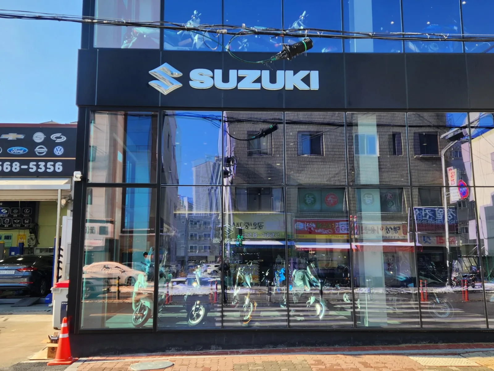 쇼룸 건물 정면 전경, SUZUKI 로고와 문자 채널사인이 부착된 2층 건물 외벽